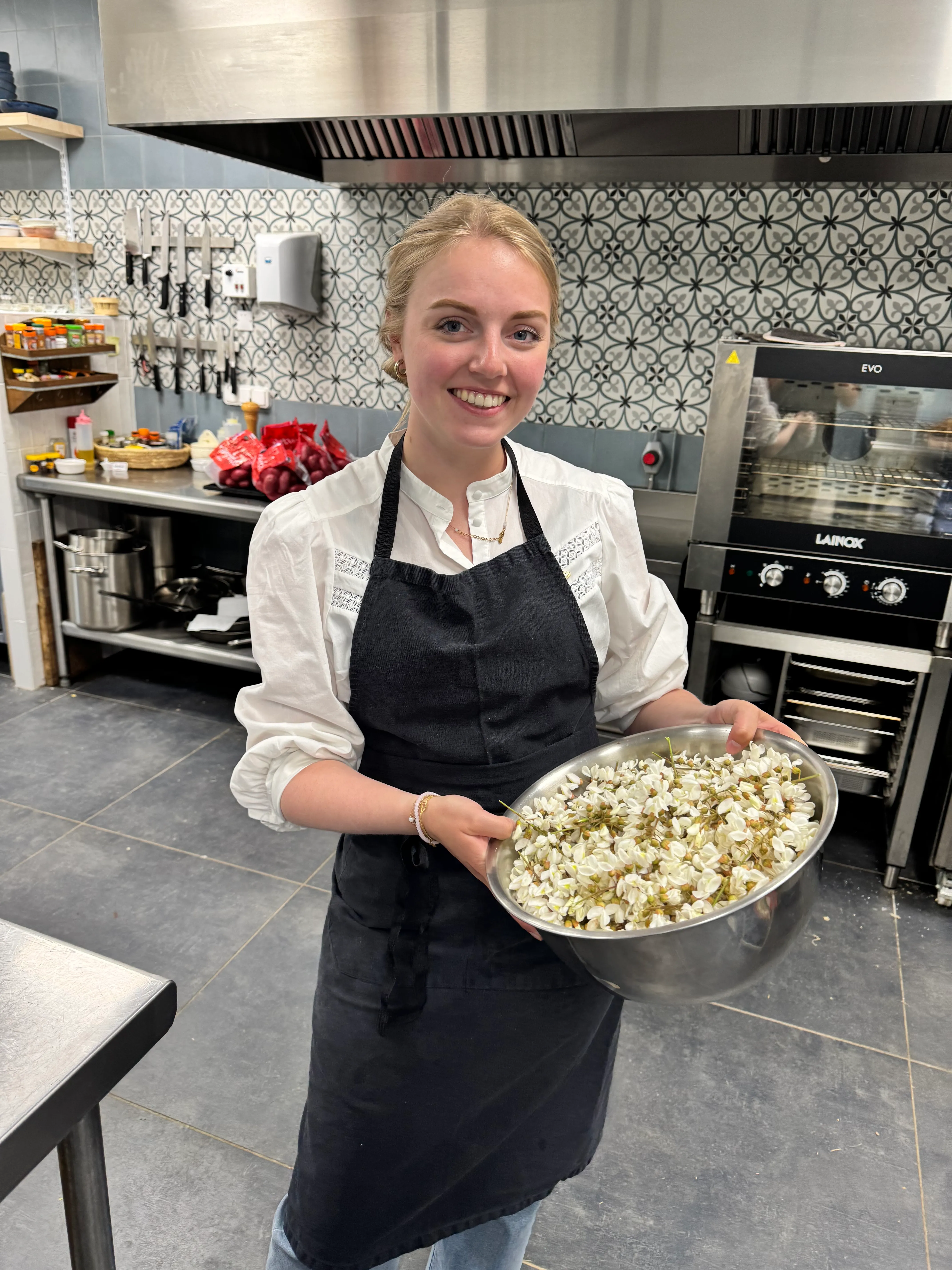 Fleur in een professionele keuken met een grote kom acaciabloesem