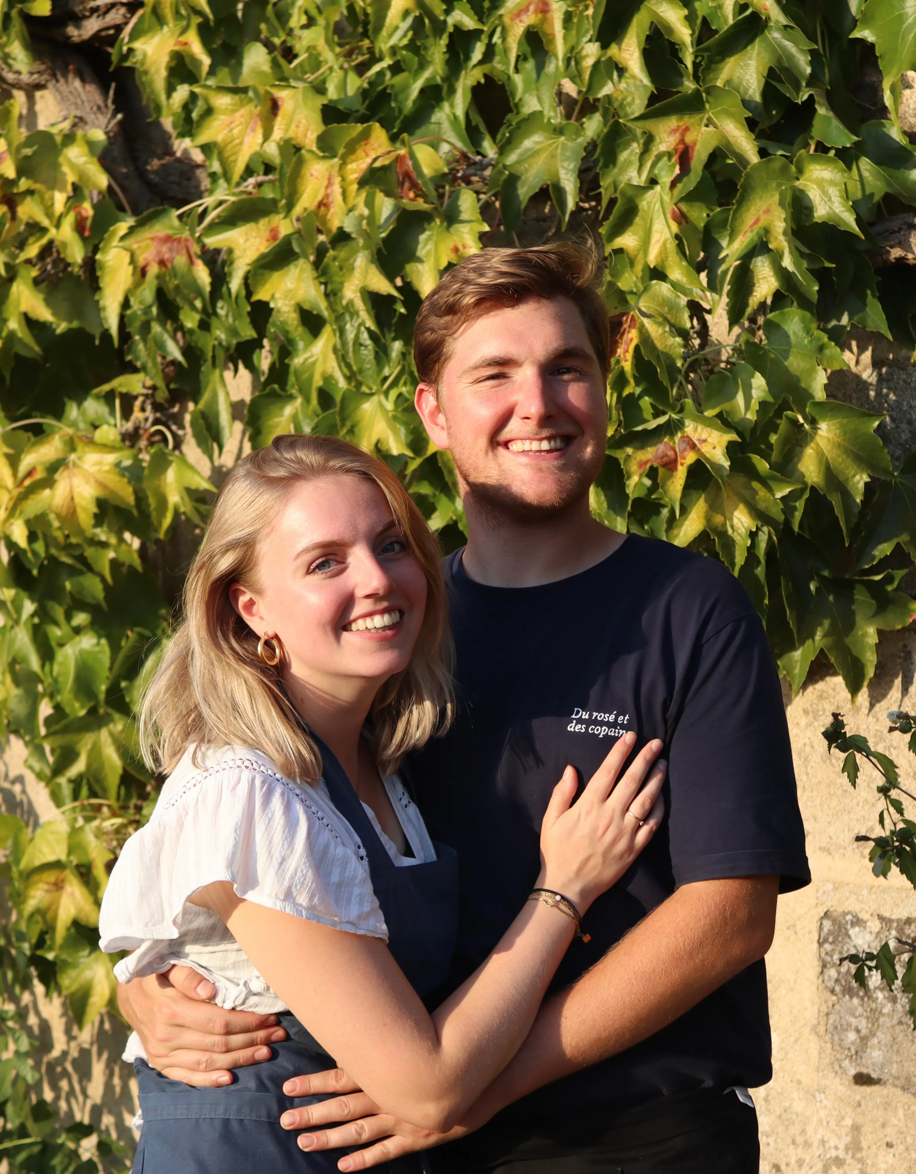 Fleur en Laurens samen voor een muur vol wingerd in de avondzon