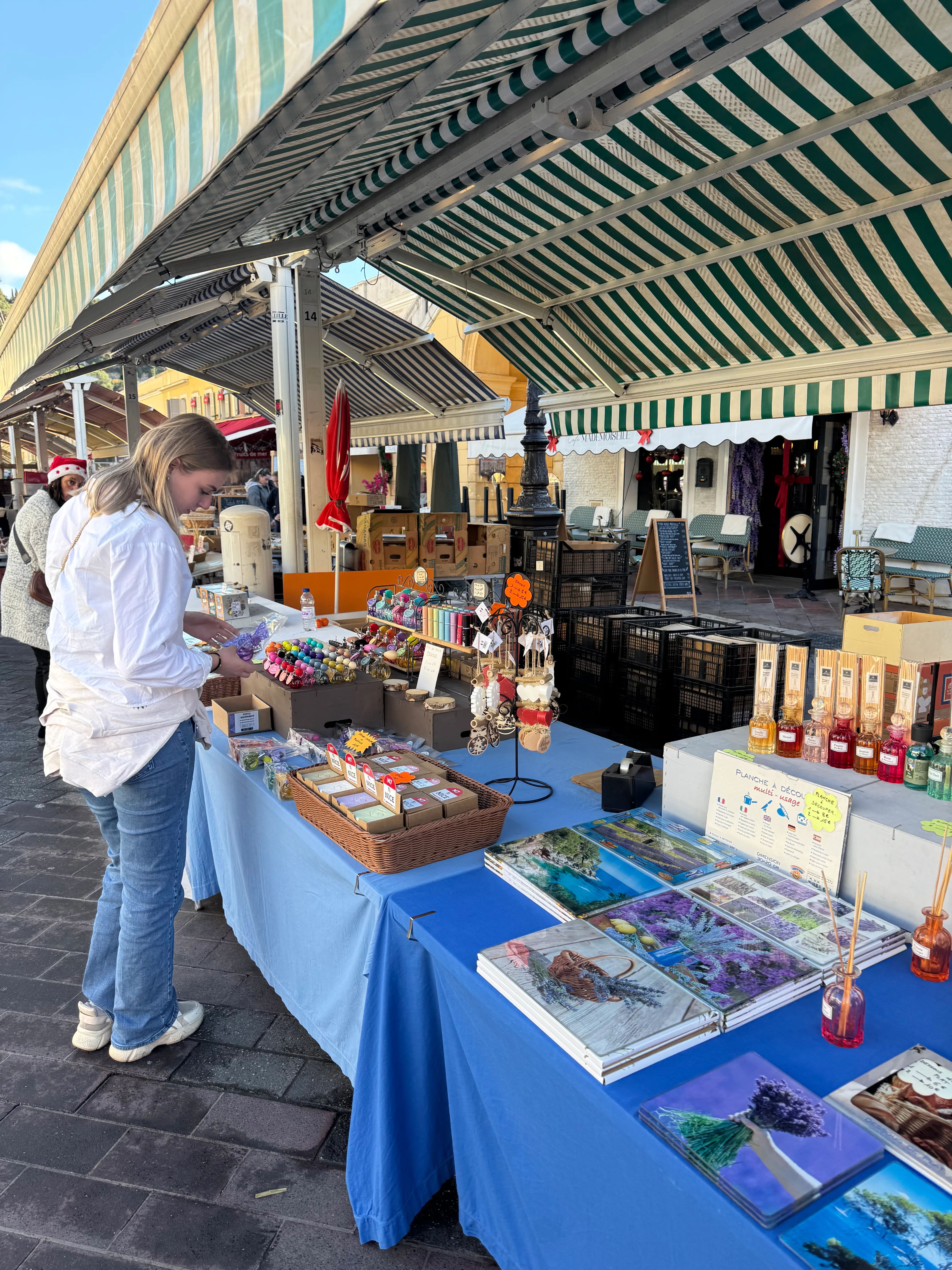 Fleur bij een marktkraam met lavendelproducten onder een gestreept zeil